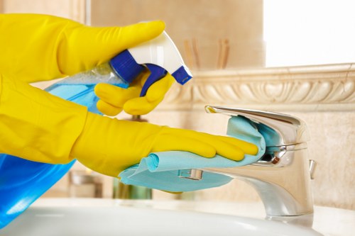 Local office cleaning service wiping desks and shared surfaces in SW13